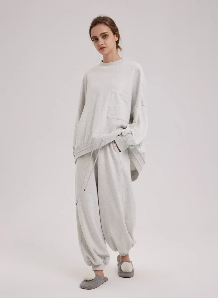 Girl wearing Cloud Color Nap Loungewear Cotton Track Set with grey slippers that have a white poof on them 
This is the product that was reviewed