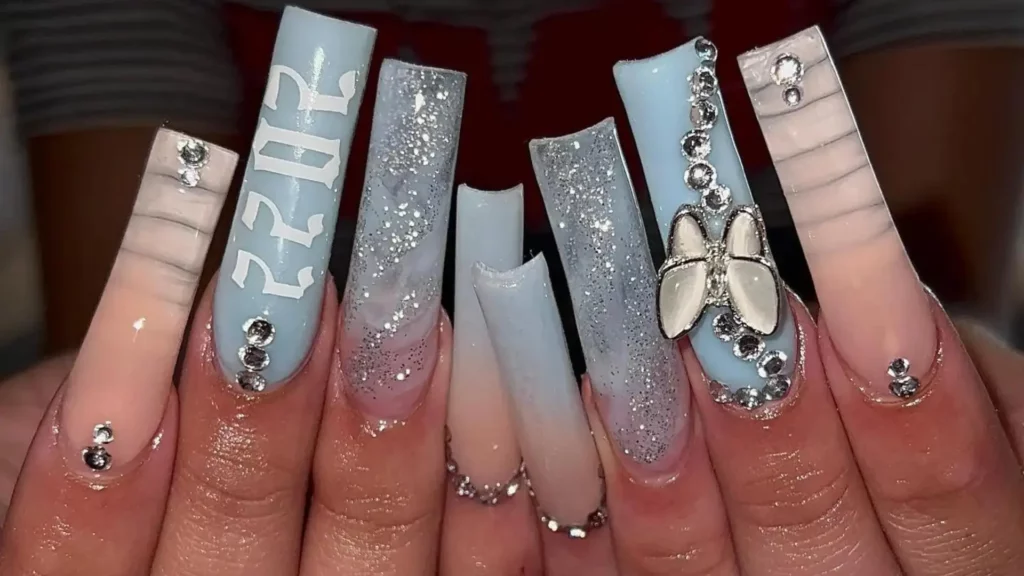 set of long square light blue nails with sparkles, a butterfly, and the number 2022
