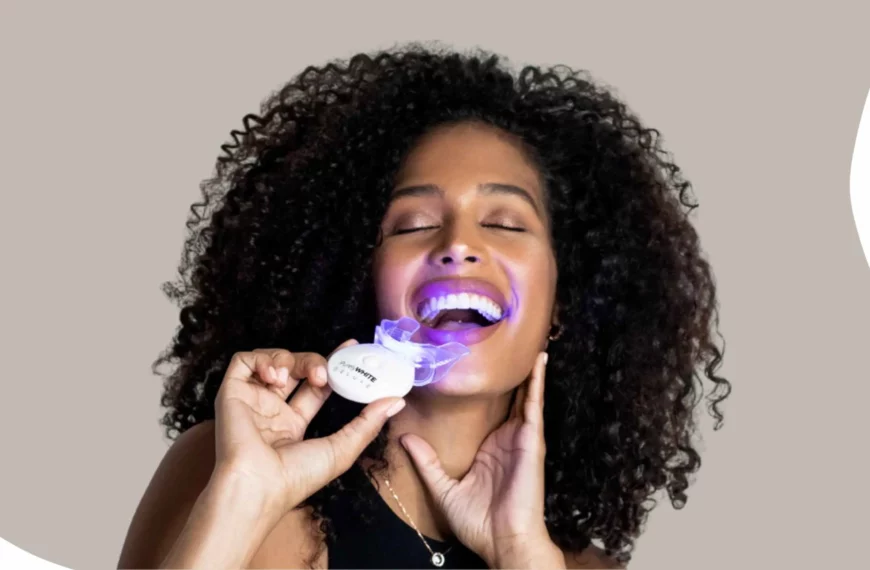 woman smiling, closing eyes, holding an LED purely white deluxe teeth whitener