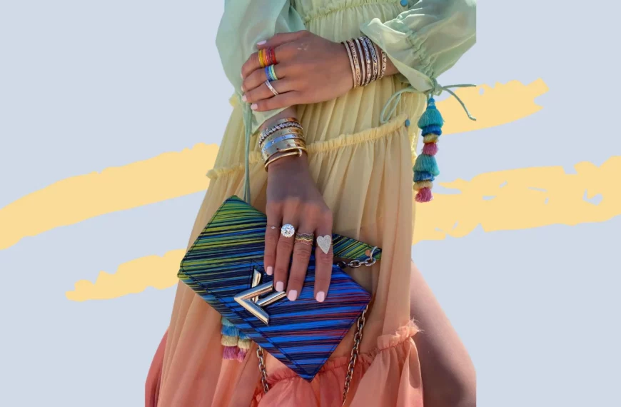 close up of a woman's hands and arms wearing bracelets and rings and holding a designer purse from vivrelle
