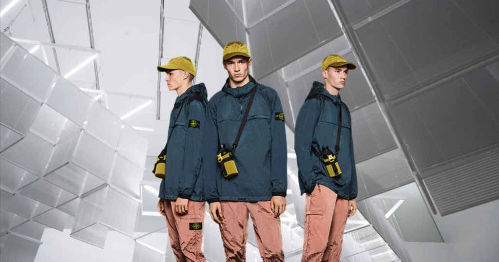 3 of the same man from different angles, wearing techwear like a yellow hat, navy technical jacket, and light pink pants