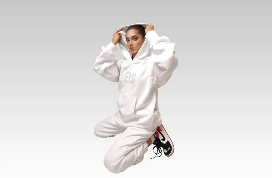woman sitting on knees, dressed in all white sweatshirt and sweatpants