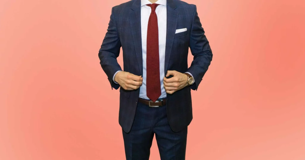 modern fit vs slim fit: man wearing dark blue plaid suit and red tie
