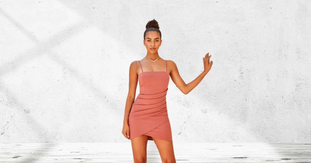 woman with hand against wall wearing short pink dress from Windsor