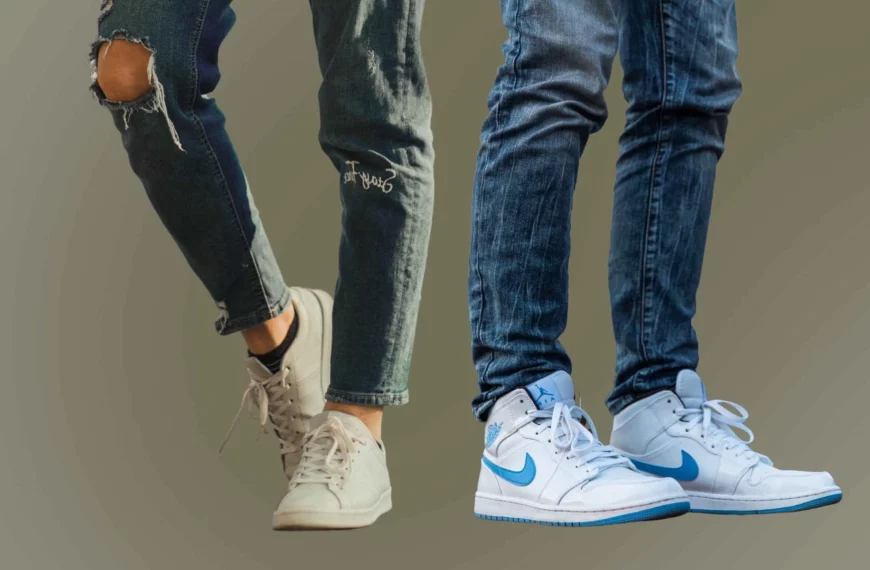 close-up of two sets of legs and feet, one person wearing athletic fit jeans and white shoes, another person wearing slim fit jeans and white shoes