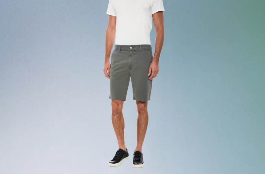 close up of man wearing white top, gray shorts, and black shoes