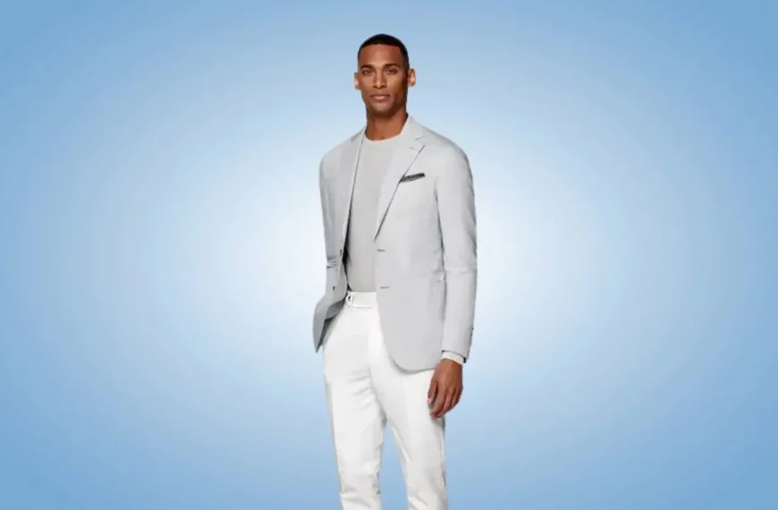 man looking into camera wearing gray suit jacket, shirt, and white pants from suitsupply