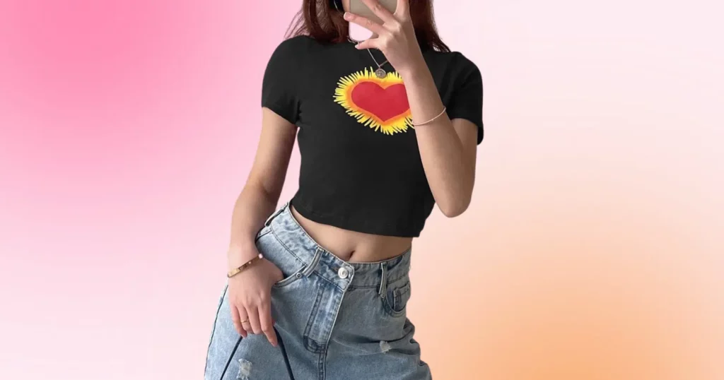 up close of woman wearing black top with yellow and red heart and jeans from Lovely Erica
