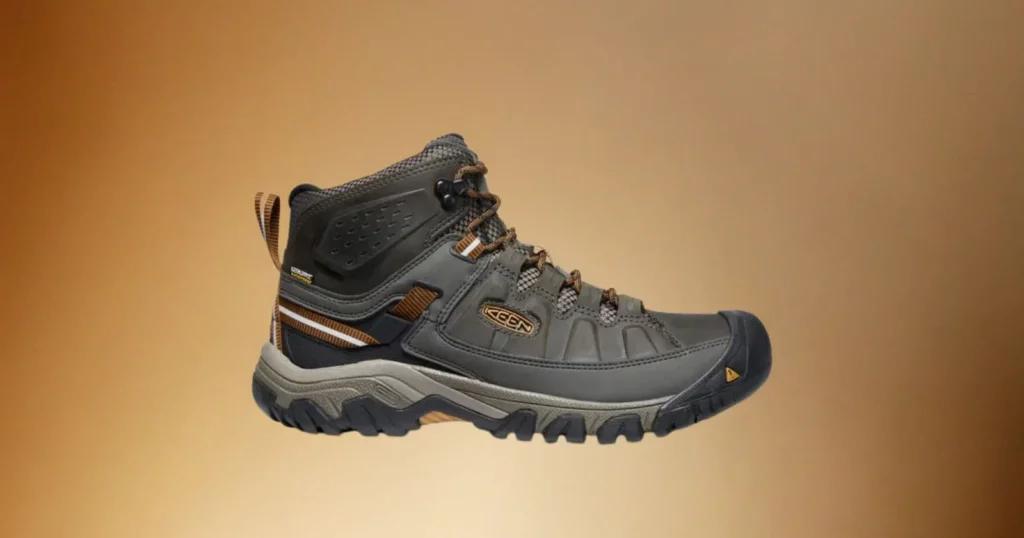 black Keen hiking boot on brown background