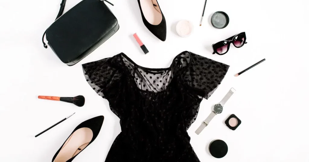 curated outfit including black dress, heels, purse, and accessories and makeup