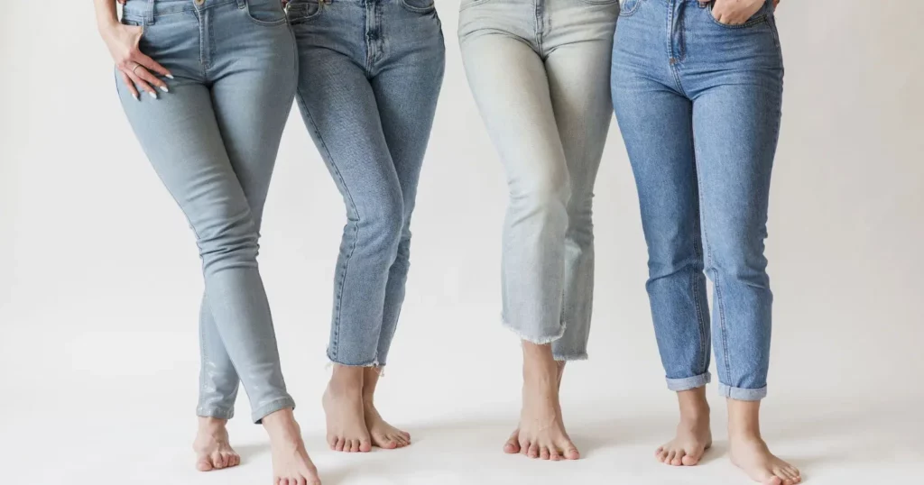 close up of four person's legs, each of them wearing a pair of blue boyfriend jeans or girlfriend jeans