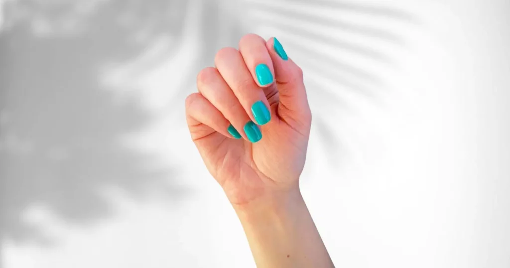 close up of person's hand with teal nail polish from Dazzle Dry