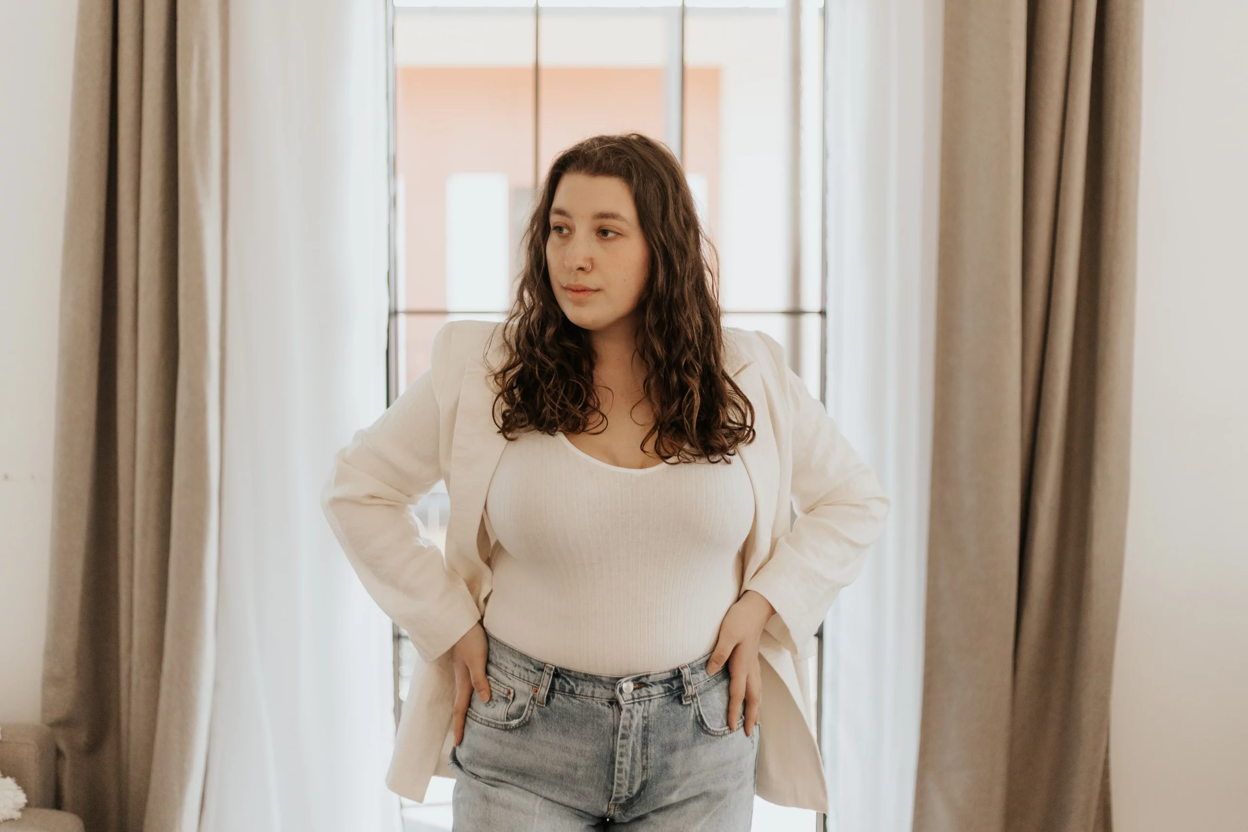 40 best plus size clothing brands featured image, girl wearing jeans + white top with white jacket